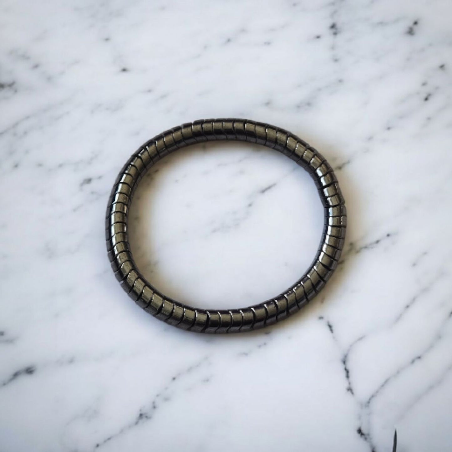 Shiny Black magnetic hematite beaded bracelet on a marble surface. Photo and bracelet by Divalicious Designs.