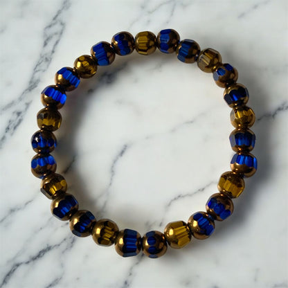 Blue and gold glass beaded bracelet and on a white by Divalicious Designs.