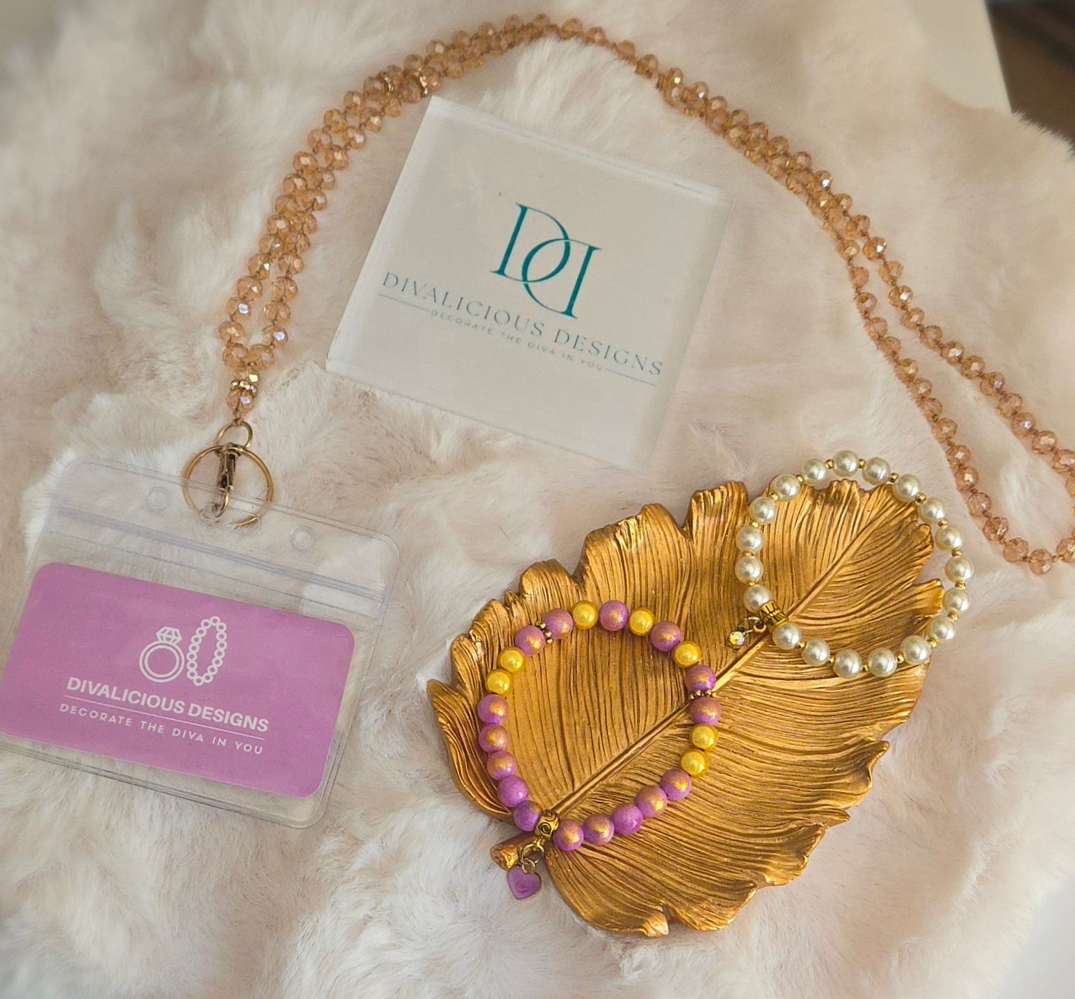 Stretch Bracelets and A crystal lanyard made by Divalicious Designson a white and golden display.