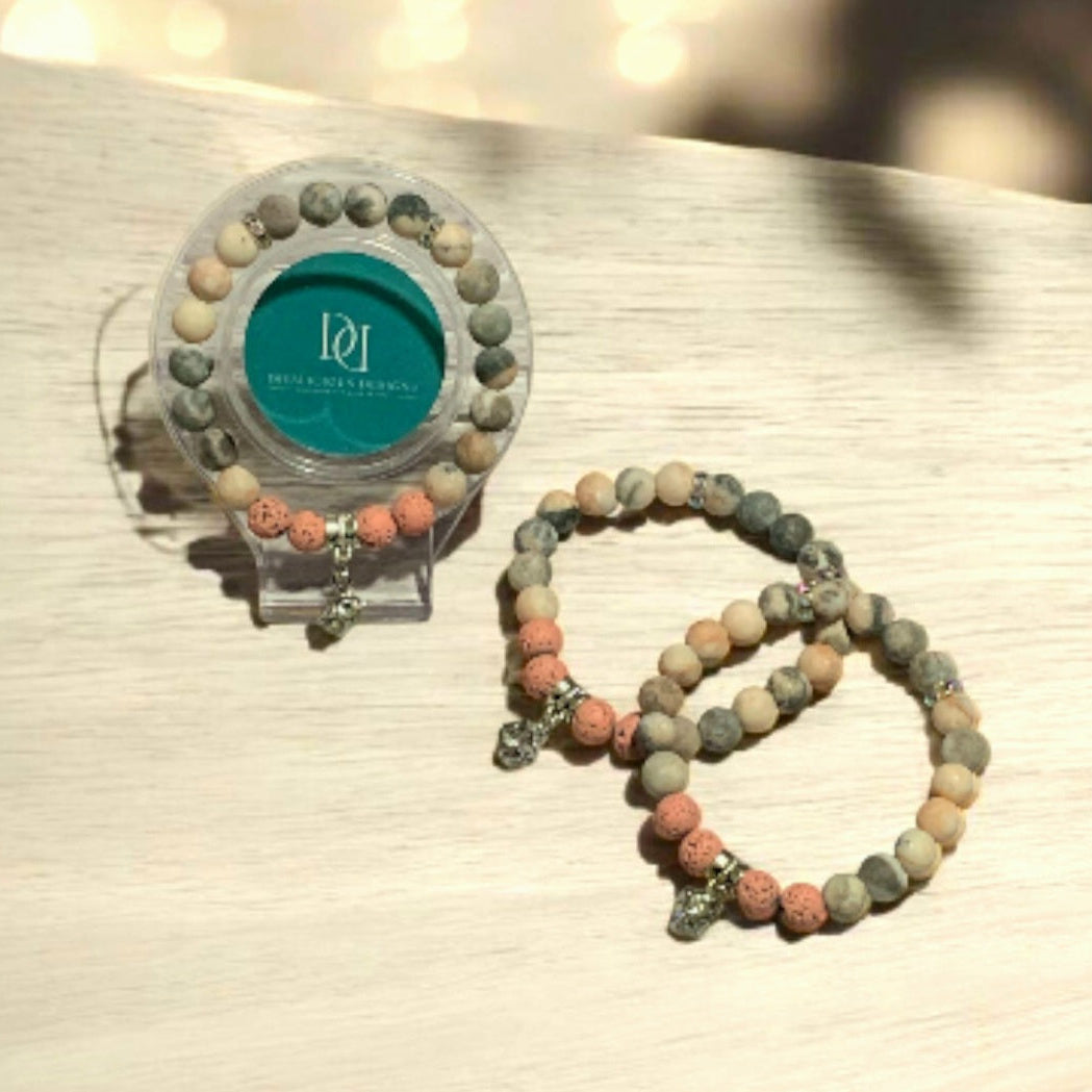 Matte Pink Zebra Jasper Beaded bracelet with a clear holder on a textured surface