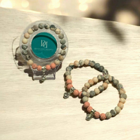 Matte Pink Zebra Jasper Beaded bracelet with a clear holder on a textured surface