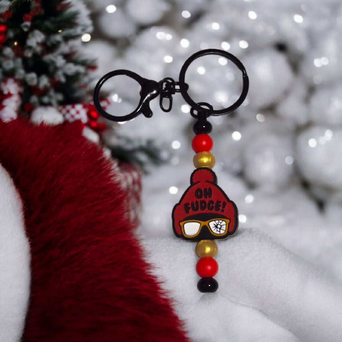 Keychain with a character wearing a red hat and sunglasses on a snowy background
