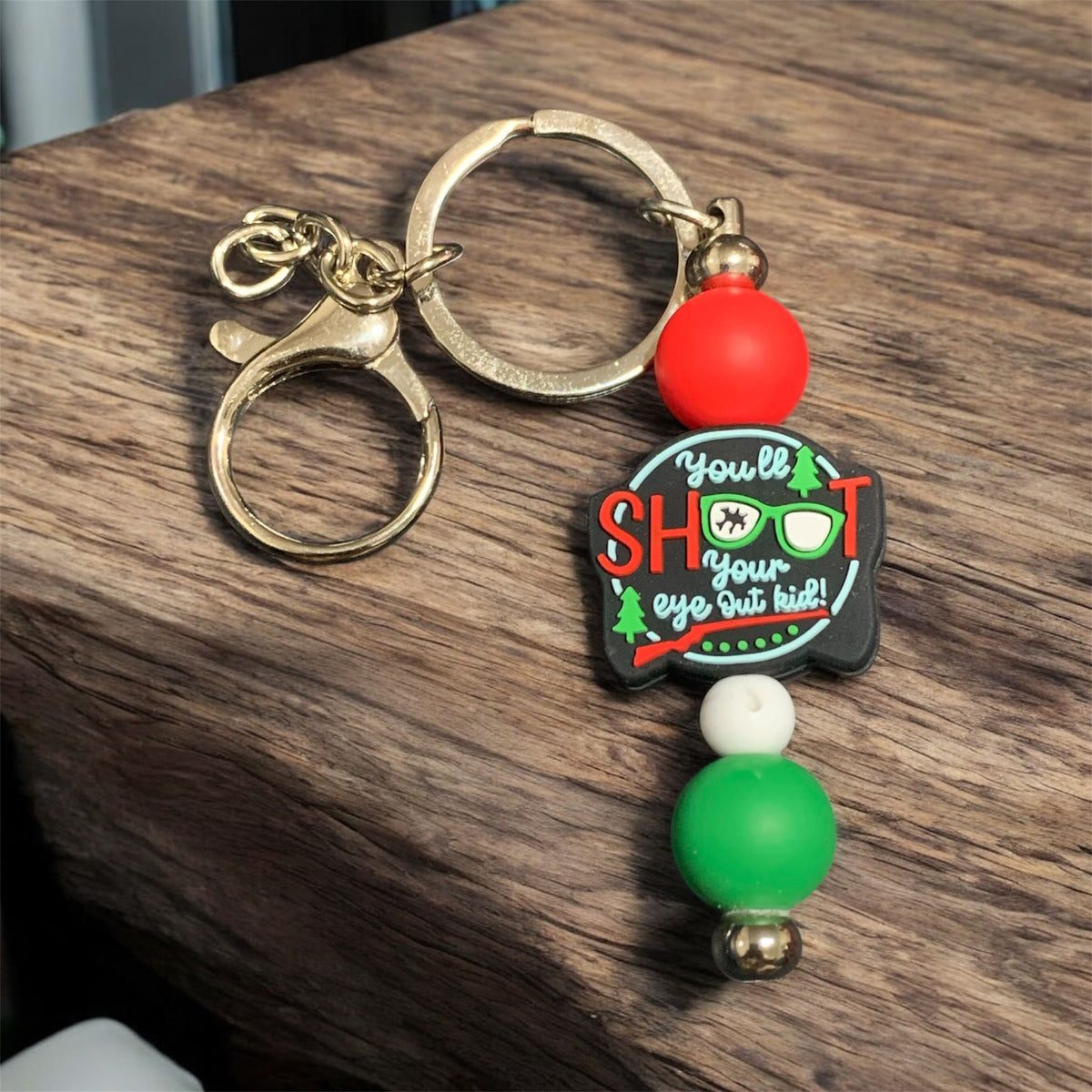 A Christmas Story Keychain with colorful beads on a wooden surface. 