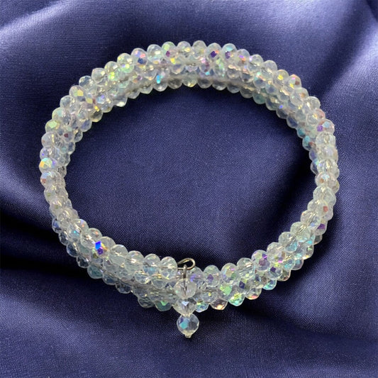 Austrian Crystal Memory Wrap Beaded bracelet. The crystals have a Swarvoski style coating. Displayed on a purple satin fabric.  Bracelet and Photo by Divalicious Designs.