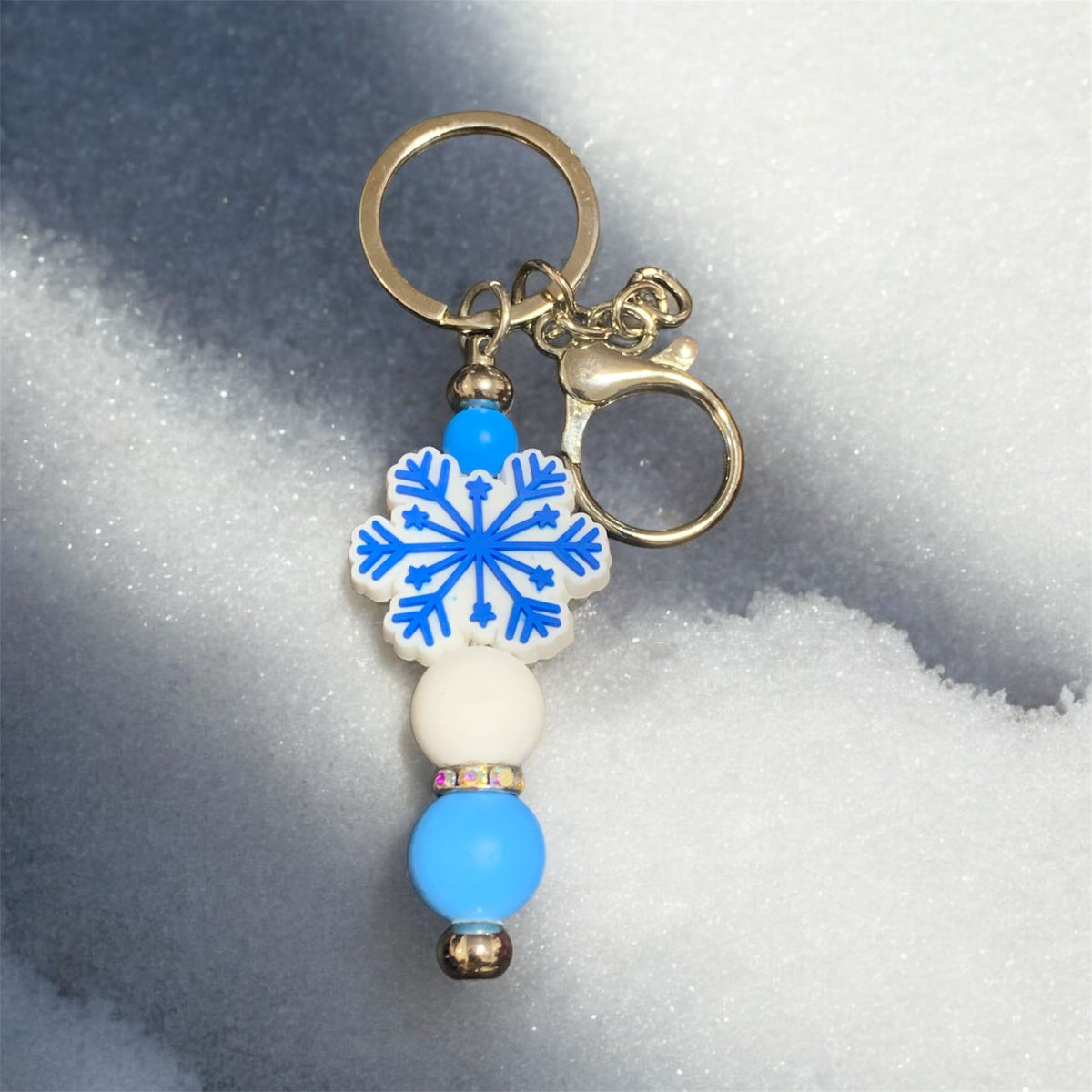 Keychain with blue snowflake design on a snowy background