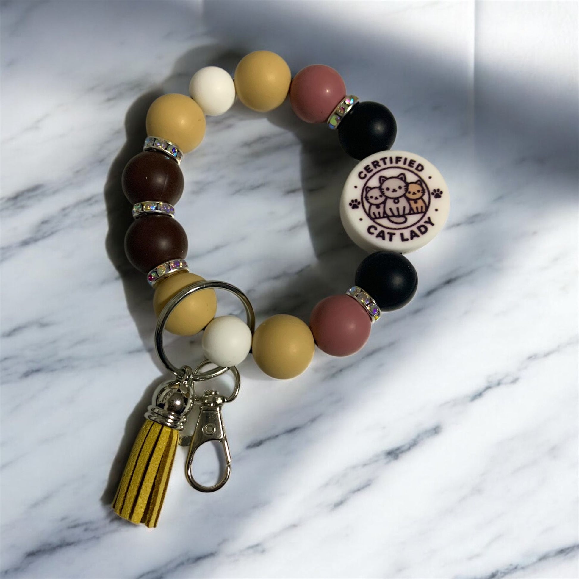 Beaded silicone keychain bracelet with 'Certified Cat Lady' focal bead on a marble background.