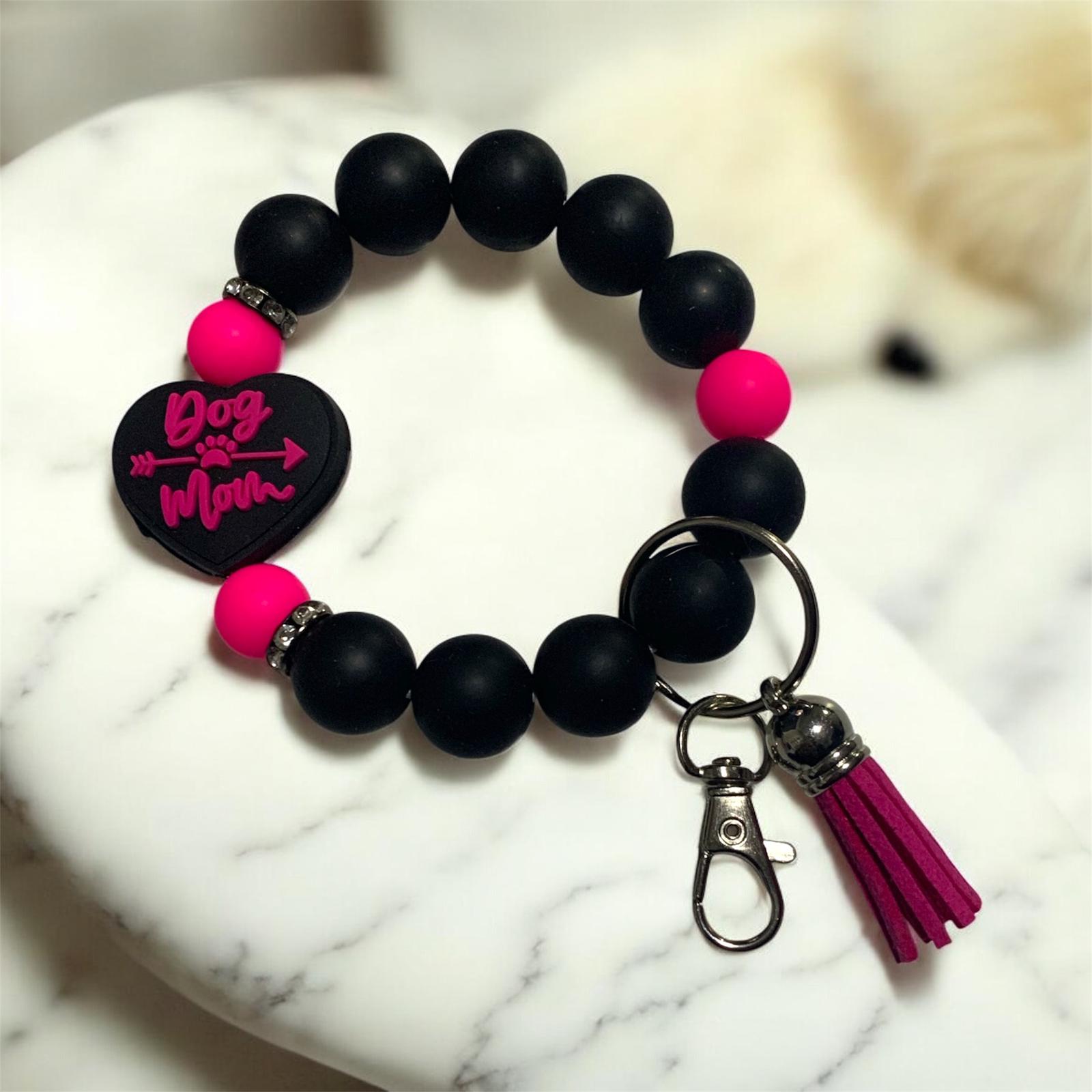 Black beaded keychain bracelet with hot pink heart focal bead that says, Dog Mom on a marble surface