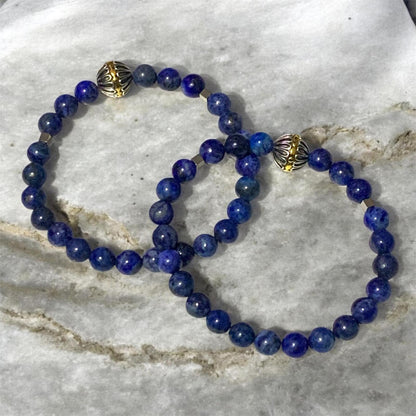 Handmade men’s Lapis Lazuli bracelet with stainless steel accents and silver gold Tibetan centerpiece bead on marble background by Divalicious Designs.