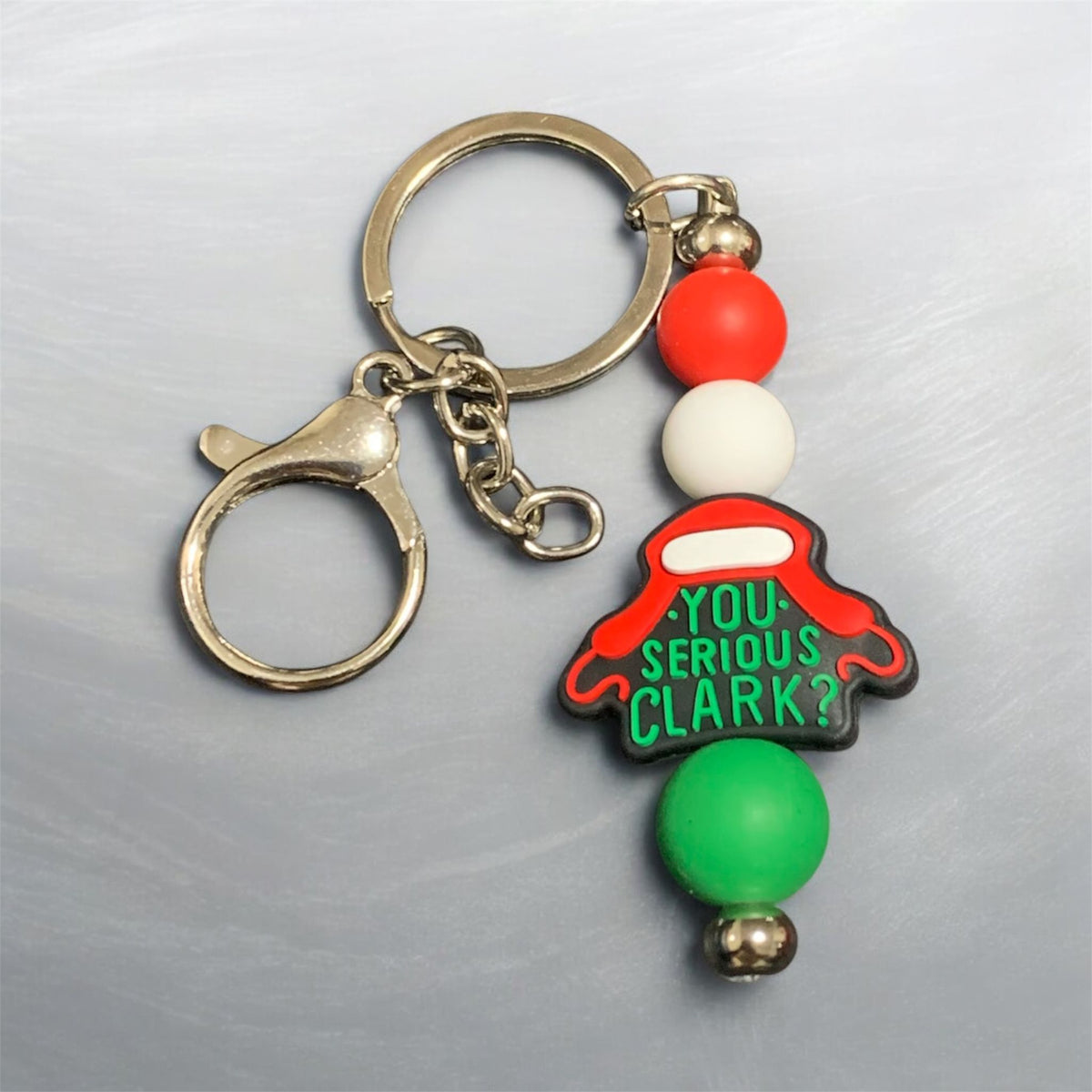 Keychain with colorful beads and a character-themed tag on a gray background