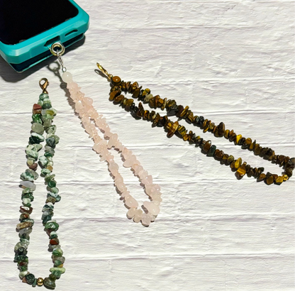 Three stone chip lanyards on a textured white surface with a turquoise phone case. Photo and lanyard made by Divalicious Designs.