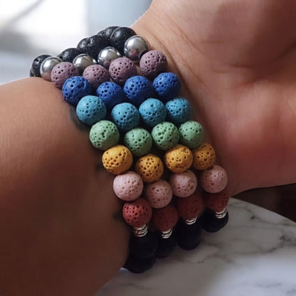 Reiki bracelets made with lava beads stacked on a wrist.