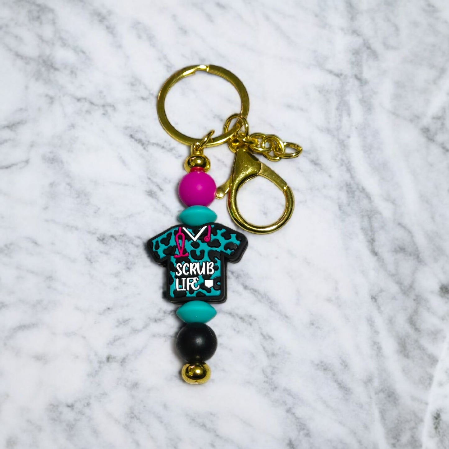 Keychain with colorful beads and 'Scrub Life' design on a marble background