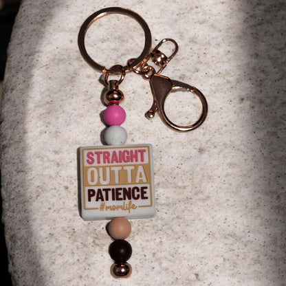 Keychain with 'Straight Outta Patience' tag on a textured surface