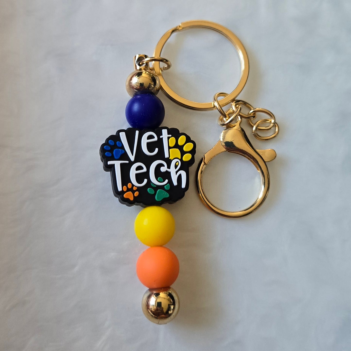 Keychain with 'Vet Tech' charm and colorful beads on a light gray background
