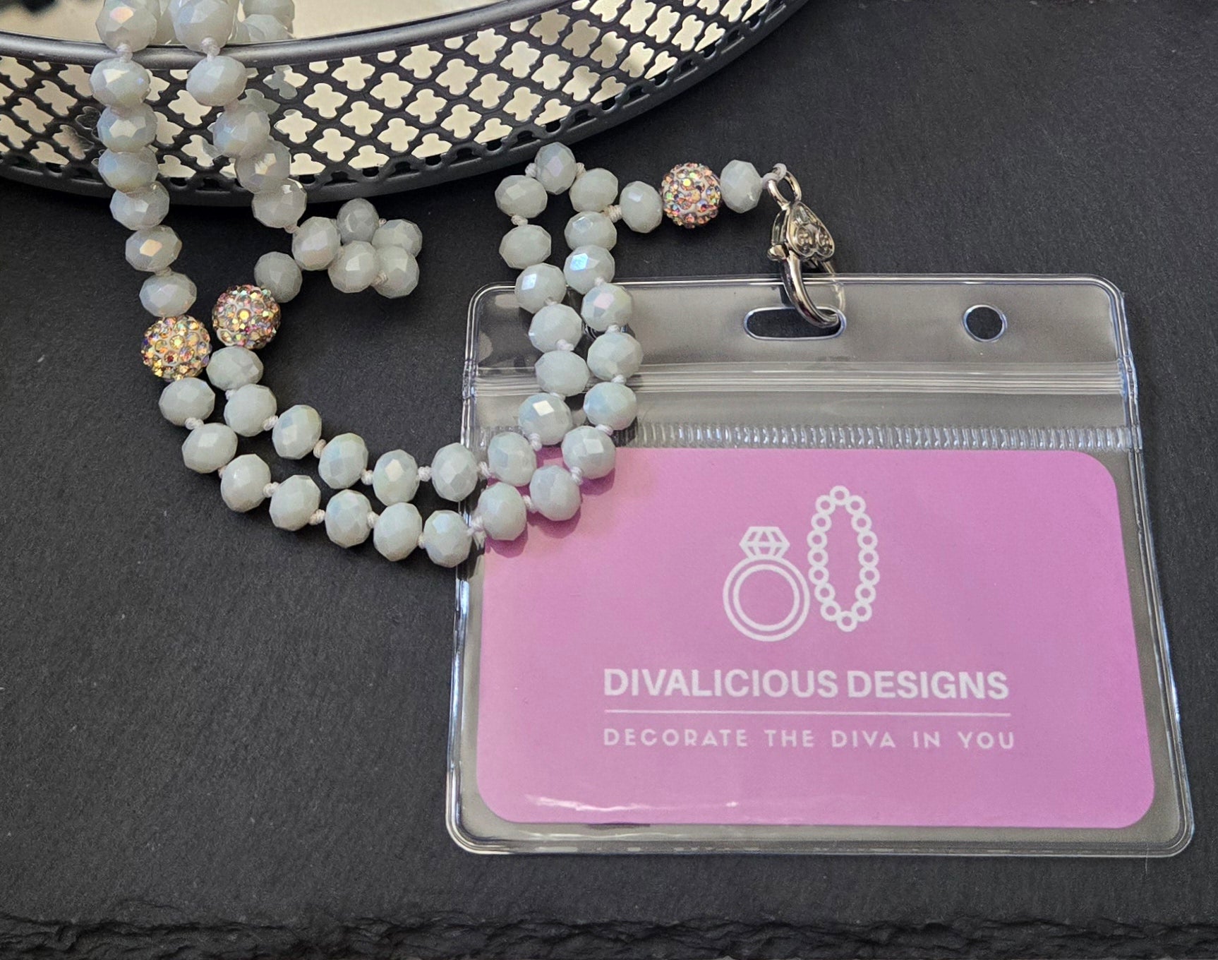 White Crystal beaded necklace with a clear card holder on a dark surface.
