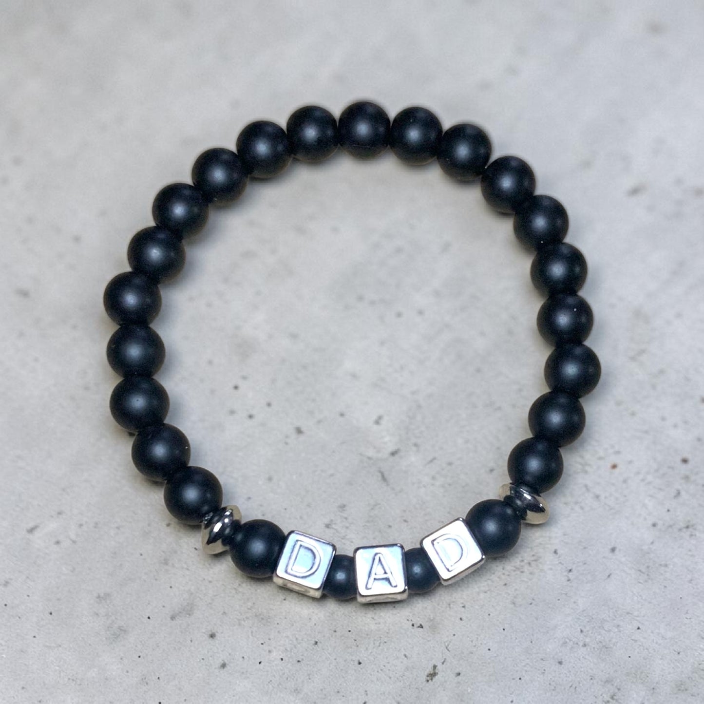 Handmade matte onyx dad bracelet with stainless steel DAD letter beads and silver accent spacers for Father’s Day gift.