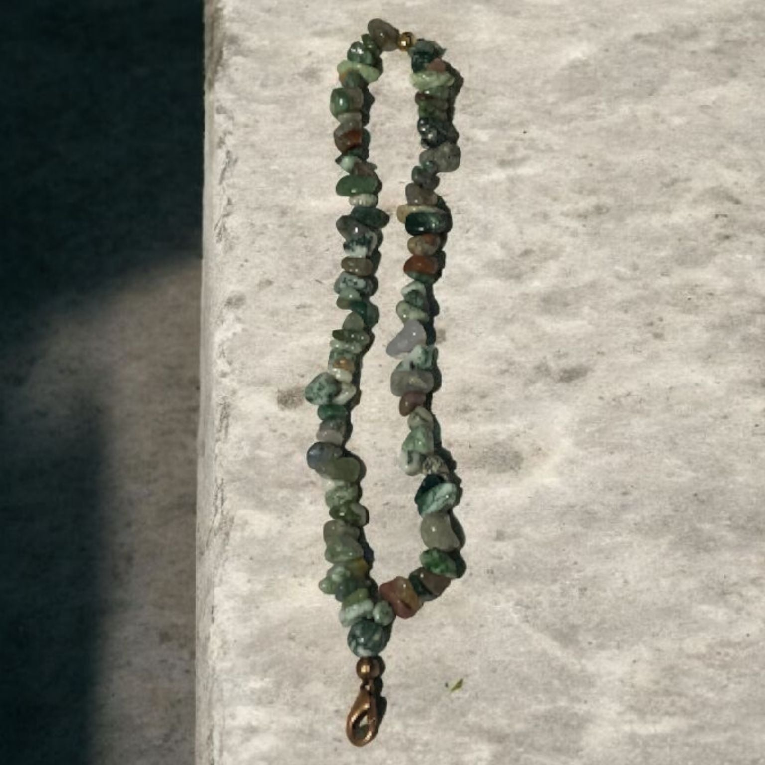 A phone lanyard made of India Agate Stone Chip Beads on a granite surface. Photo and lanyard made by Divalicious Designs.
